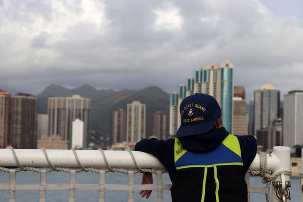 A family member of a U.S. Coast Guard Cutter Kimball crew member looks at Honolulu's skyline.