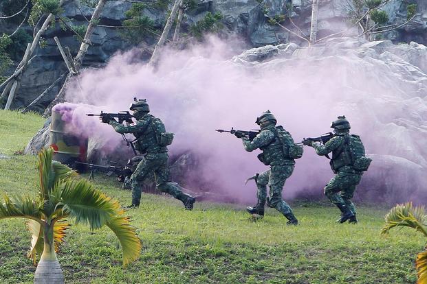 Soldiers from Taiwan's special forces move past colored smoke during a helicopter landing training.