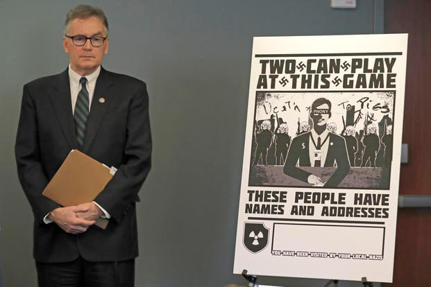U.S. Attorney Brian Moran stands next to a poster that was mailed to the home of Chris Ingalls