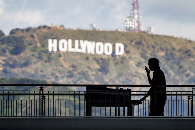 A worker wheels equipment past the famous Hollywood sign as preparations continue for the 95th Academy Awards.
