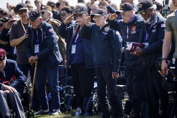 U.S war veterans salute during a ceremony outside the Pegasus Bridge memorial in Benouville, Normandy