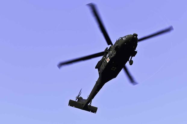 An HH-60 hovers overhead