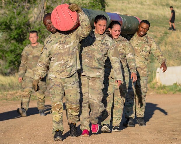 Soldiers assigned to 4th Infantry Division Artillery carry a log up a hill at Fort Carson, Colorado. 