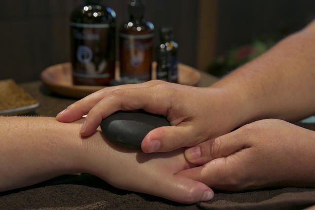 A woman receives a warm stone hand massage at the 2014 International Spa Association event in New York. 