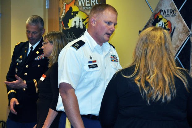 Capt. Joseph Ledger, foreground, manager of the Wisconsin Employment Resources Connection (WERC), speaks with an attendee during a symposium on hiring veterans to business leaders in Madison, Wis.