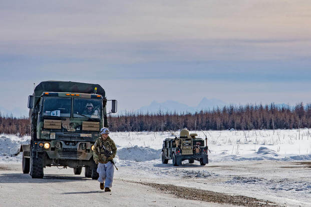 Soldiers move a Light Medium Tactical Vehicle across an assembly area to refuel before lining up for convoy operations on their way to Yukon Training Area, Alaska. 