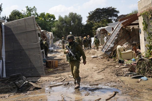 An Israeli soldier walks in kibbutz Kfar Azza