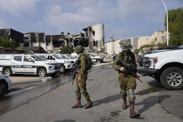 Israeli soldiers walk near the police station that was overrun by Hamas militants.