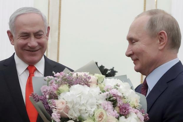 Russian President Vladimir Putin prepares to greet Israeli Prime Minister Benjamin Netanyahu's wife Sara