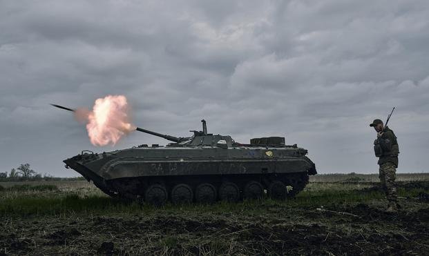 A Ukrainian APC fires towards Russian positions near Avdiivka, in the Donetsk region