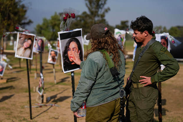 Israeli soldiers look at photos of people killed and taken captive by Hamas militants