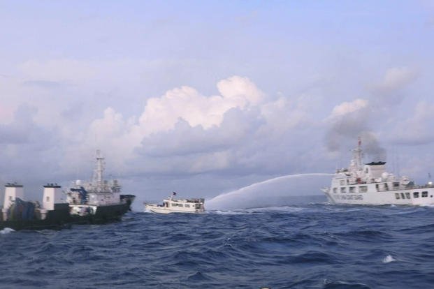 A Chinese Coast Guard ship uses water cannons on Philippine navy-operated supply boat M/L Kalayaan.