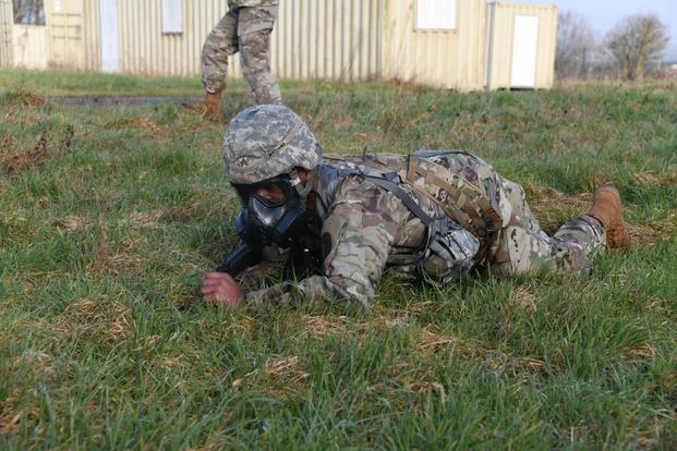 U.S. Army Staff Sgt. Jordan Williams, veterinary food inspector, crawls in a gas mask during Rheinland-Pfalz Best Warrior Competition for Public Health Activity, Chièvres Air Base, Belgium, Feb. 15, 2023.