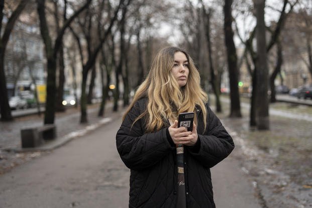 Yevheniia Synelnyk, whose brother has been in captivity for over a year and a half, stands in a park
