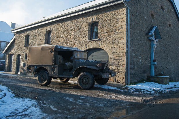 A Dodge WC series light truck is parked in front of a barn during the commemorations of Battle of the Bulge's 70th anniversary in Bastogne, Belgium.