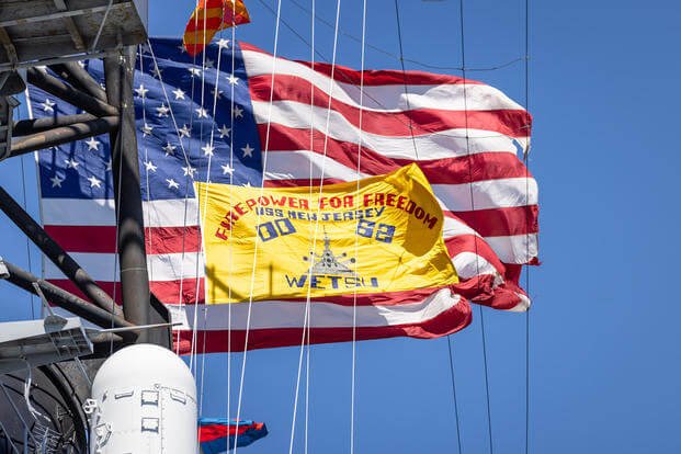 The USS New Jersey displays its battle flag as it leaves Camden, N.J., for dry docking in Philadelphia.