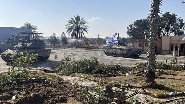 a tank with an Israel flag on it entering the Gazan side of the Rafah border crossing