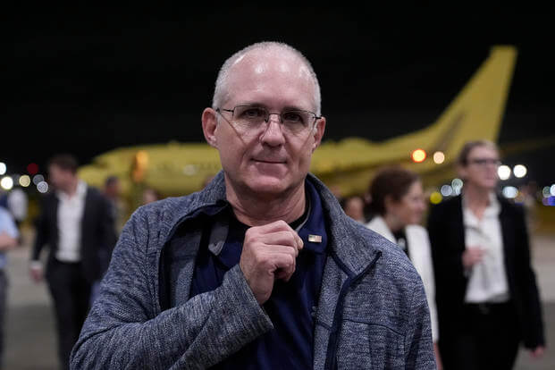 Paul Whelan shows a pin he received from President Joe Biden.