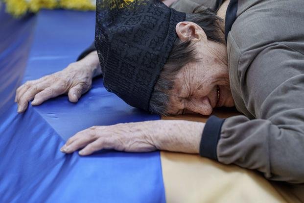 A mother cries near the coffin of her son killed in a Russian rocket attack.