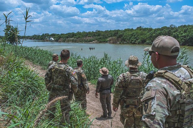 Soldiers from the Texas National Guard watch a Border Patrol helicopter