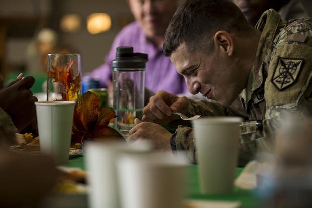 Sgt. Michael Carter, a U.S. Army Reserve supply sergeant, takes a bite of food during the command staff's Thanksgiving luncheon at Fort Meade, Maryland.