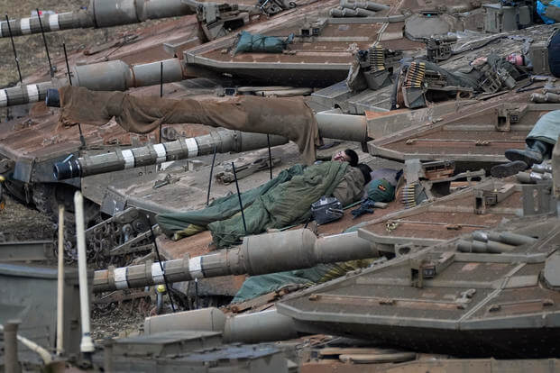 Israeli soldiers sleep on tanks in a staging area in northern Israel near the Israel-Lebanon border