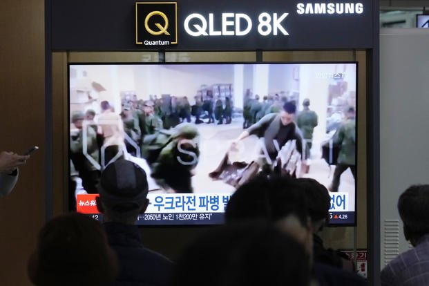  A TV screen shows an image of soldiers believed to be from North Korea