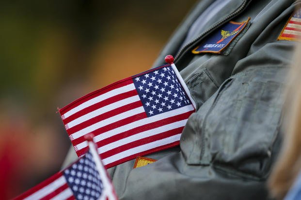 A veteran tucks a flag into his jacket while cheering during the Veterans Day Parade in Virginia Beach, Virginia, on Nov. 11, 2024. 