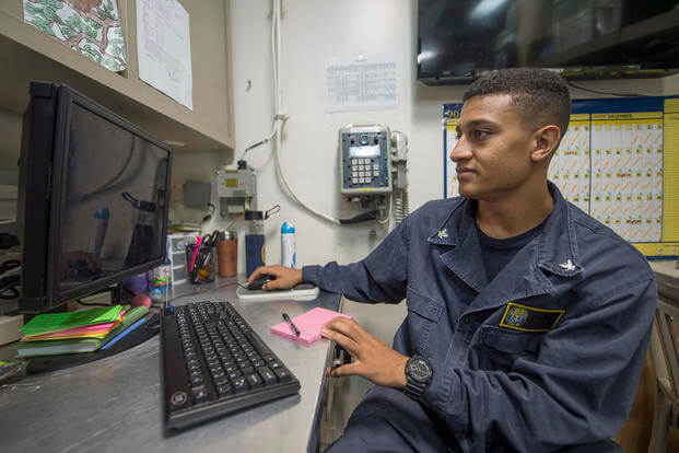 Petty Officer 3rd Class Giovanni Gonzalez processes correspondence in the ships office aboard the guided-missile destroyer USS Roosevelt (DDG 80).