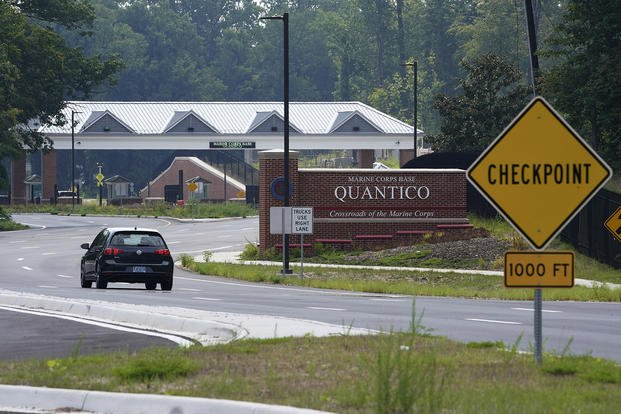 Traffic drives past the entrance sign of Marine Corps Base Quantico in Quantico, Va.