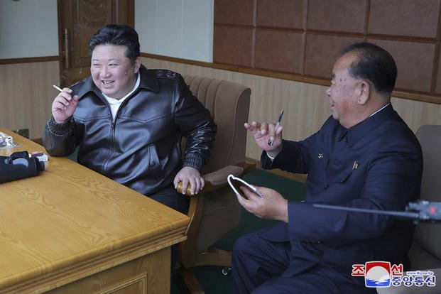 Kim Jong Un, left, inspects tests of drones designed to crash into targets