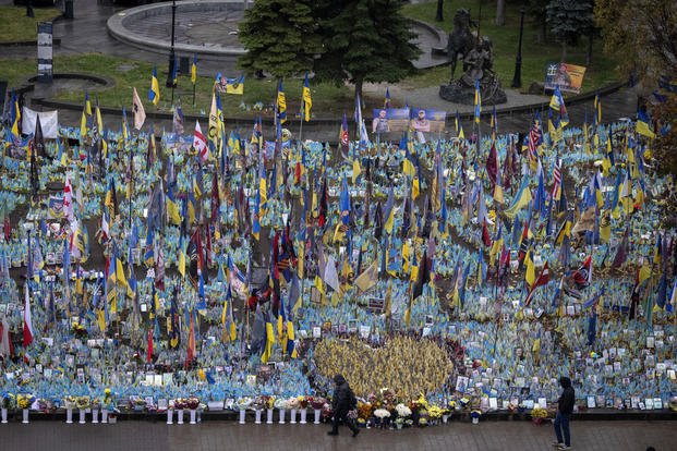 People walk past the memorial to fallen soldiers in Independence Square in Kyiv, Ukraine
