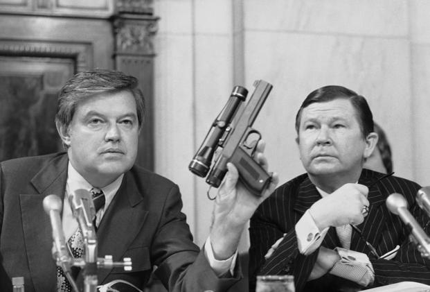 Chairman Frank Church, D- Idaho., the Senate Intelligence Committee, holds up a poison daft gun as co-chairman John G. Tower, R-Texas looks at the weapon during a session the panel's probe of the Central Intelligence Agency Tuesday, Sept. 17, 1975 in Washington.