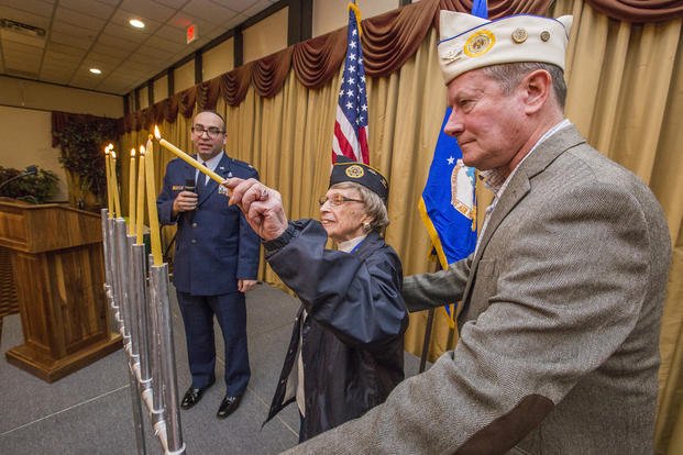 World War II veteran May Brill, center, participates in a Hanukkah candle-lighting ceremony.