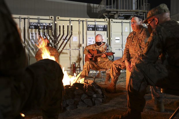 U.S. Army Maj. Kenneth May, deputy command chaplain at U.S. Army Central Command forward, plays the guitar for attendees of a menorah lighting ceremony on Dec. 10, 2020, on Camp Arifjan, Kuwait. 