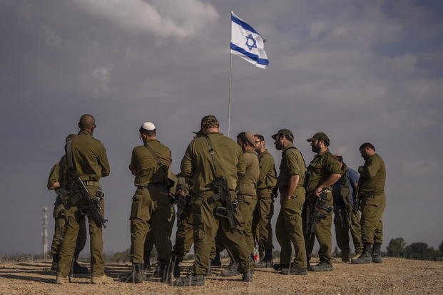 Israeli soldiers congregate on a hill close to the Gaza border in southern Israel.