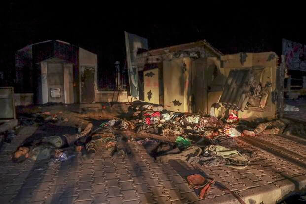 The bodies of Syrian army soldiers lie next to a vehicle after being killed in combat.