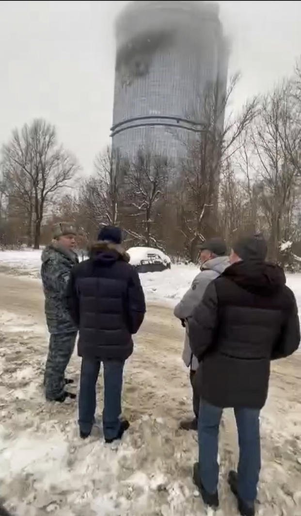 Officials look at a damage site at a residential complex in Kazan, Russia.