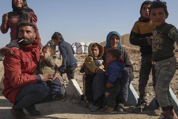 Internally displaced people sit in a camp in Tabqa city, Raqqa governorate, northern Syria