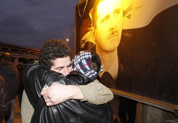 A freed Syrian prisoner, left, hugs his brother after being released from Adra Prison on the northeast outskirts of Damascus