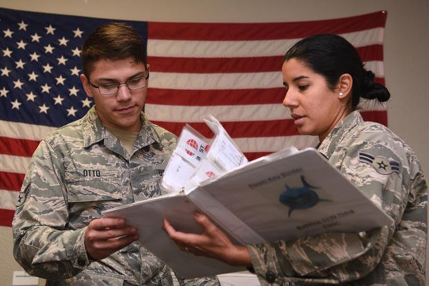 U.S. Air Force Airman 1st Class Alexander Otto, 316th Training Squadron signals intelligence analyst course graduate, discusses accountability procedures with Airman 1st Class Ligia Herrera, 316th TRS student, in the Military Training Leader’s office at the 316th TRS dormitory on Goodfellow Air Force Base, Texas.