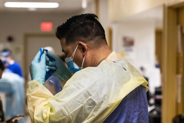 U.S. Army Reserve Sgt. Larry Moss, a licensed practical nurse assigned to Urban Augmentation Medical Task Force 352-1, puts on personal protective equipment before entering a patient’s room at Temple University Hospital, Philadelphia.