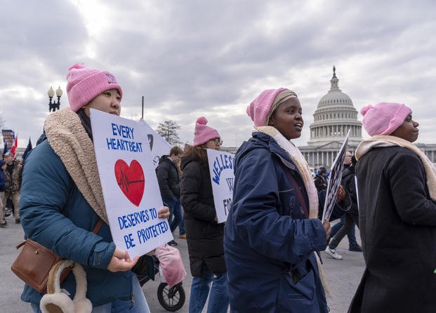 Anti-abortion activists walk past the Capitol