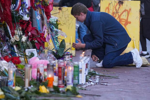 A University of New Orleans student lights a candle at memorial on Bourbon Street. 