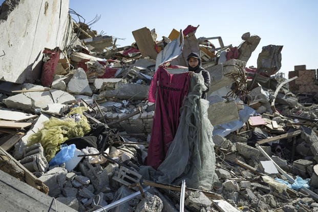 Nour Abu Al Zamar salvages items from her home in Rafah