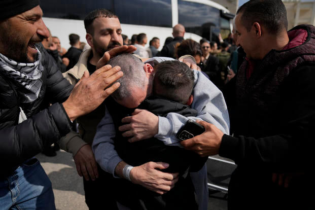 Palestinian prisoners are greeted as they exit a Red Cross bus.