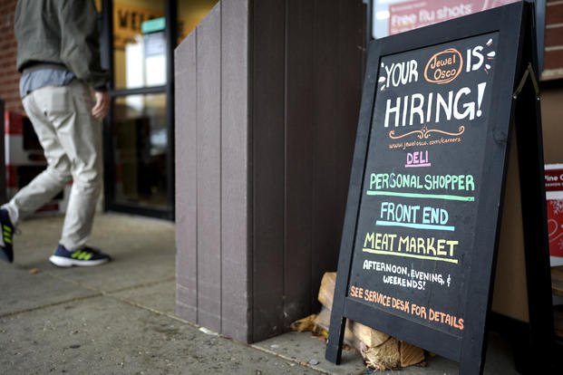 Hiring sign is displayed at a grocery store in Glenview, Ill.