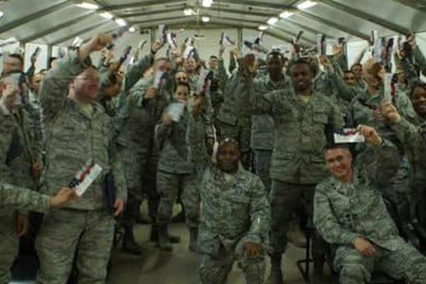 Soldiers at a Forward Operating Base in Afghanistan hold up calling cards donated by Cell Phones for Soldiers. (Cell Phones for Soldiers)
