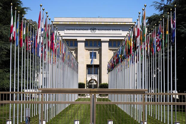 Flagpoles line in rows in front of a building of the United Nations in Geneva, Switzerland