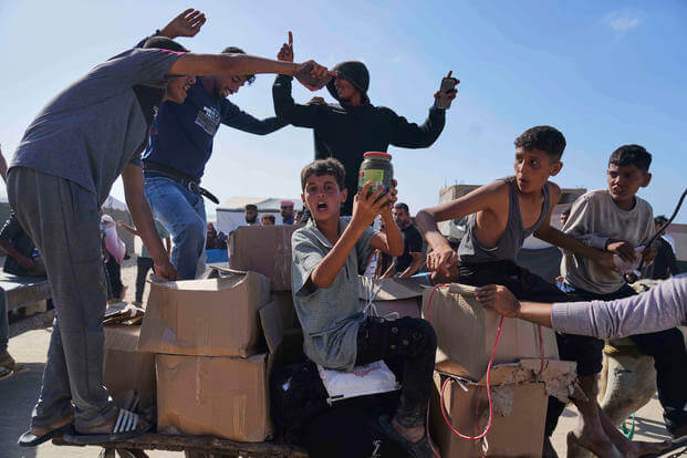 Palestinians carry boxes containing food and humanitarian aid packages 
